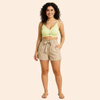 Full-length model wearing the Airy SoftFlame Wireless Lace Bra in lemon green with beige high-waisted shorts.