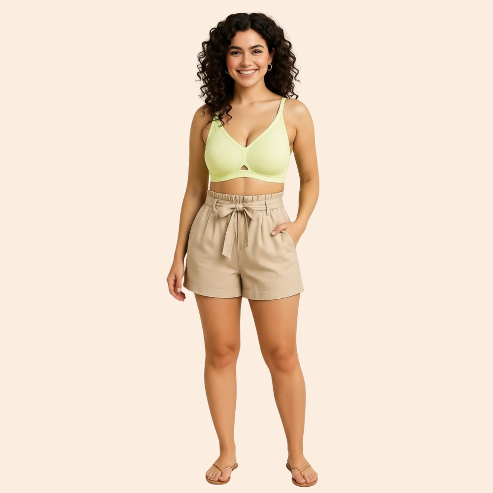 Full-length model wearing the Airy SoftFlame Wireless Lace Bra in lemon green with beige high-waisted shorts.